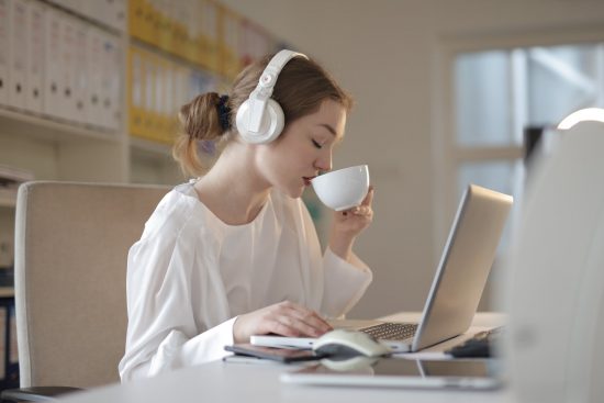 woman in white dress shirt using white laptop computer