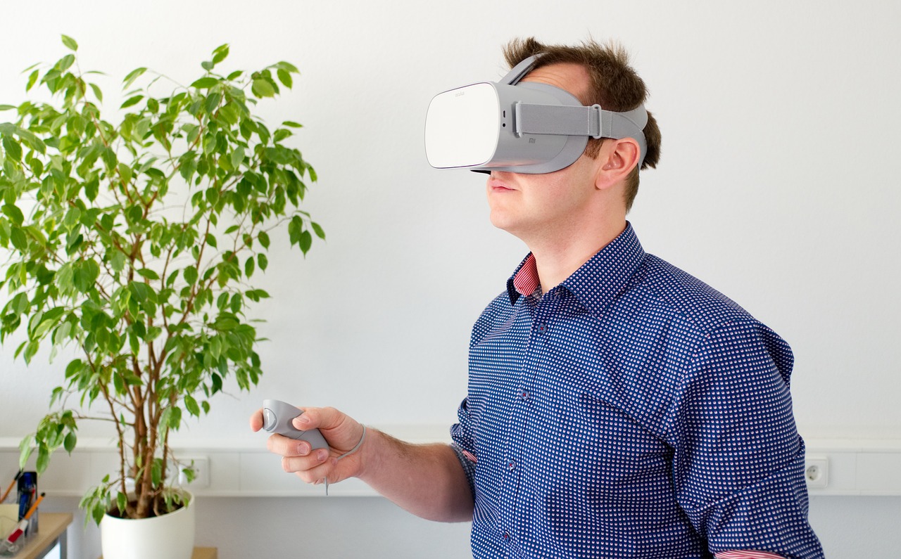 Immagine di un uomo che indossa occhiali da realtà virtuale mentre lavora su un progetto, rappresentando la tecnologia e l'innovazione che saranno parte integrante delle professioni del futuro.